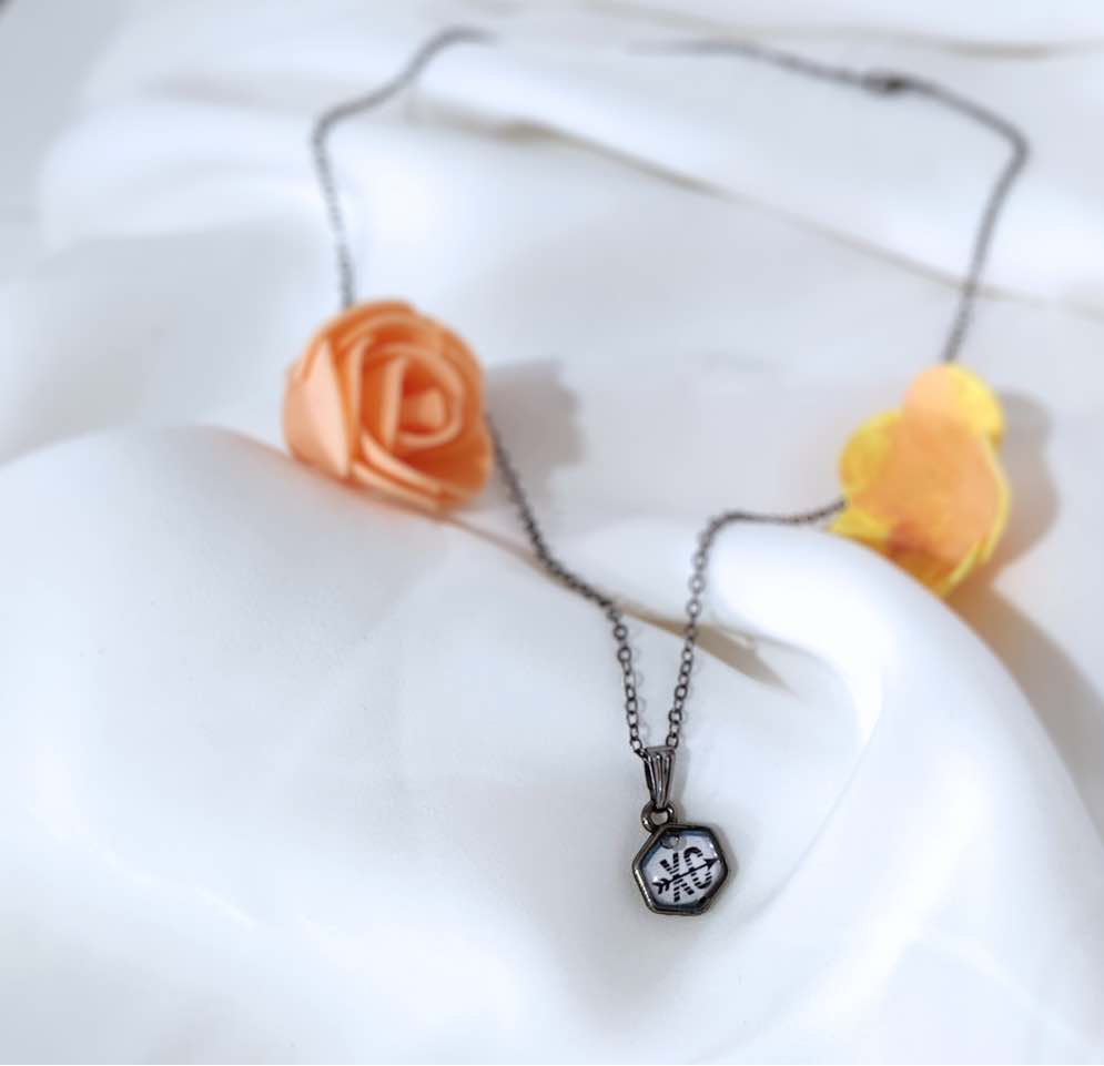 This gunmetal black necklace is handmade. It has the letters ‘XC’ with arrow across it in the clear resin dome. The stainless-steel frame and chain makes it lightweight, comfortable, and durable. The ideal gift for cross country athletes and enthusiast.