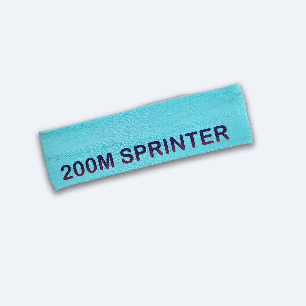 A light blue '200M Sprinter Headband' adorned with striking dark blue '200M SPRINTER' print. Made from 100% cotton with silicone for a firm grip. Tailored for track and field athletes.