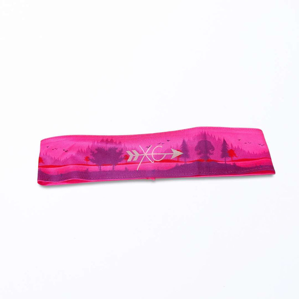 A close-up image of the XC Headband made from quality polyester fabric with silicone inside of it for firm hold. This headband has ‘XC’ colorfully printed on it.