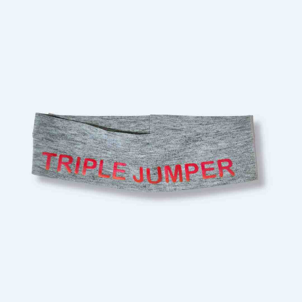 This light grey 'Triple Jumper Headband' with vibrant pink 'TRIPLE JUMPER' lettering print on it, demonstrates both style and practicality for athletes. With a silicone hold, this headband stays beautifully in place.