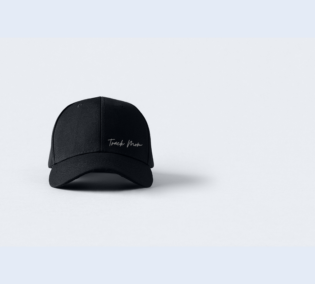 A stylish black face cap with the words "Track Mom" printed in white on the front. The cap has a curved brim, an adjustable strap closure, and is the ideal gift all track and field moms, enthusiast and  supporters.