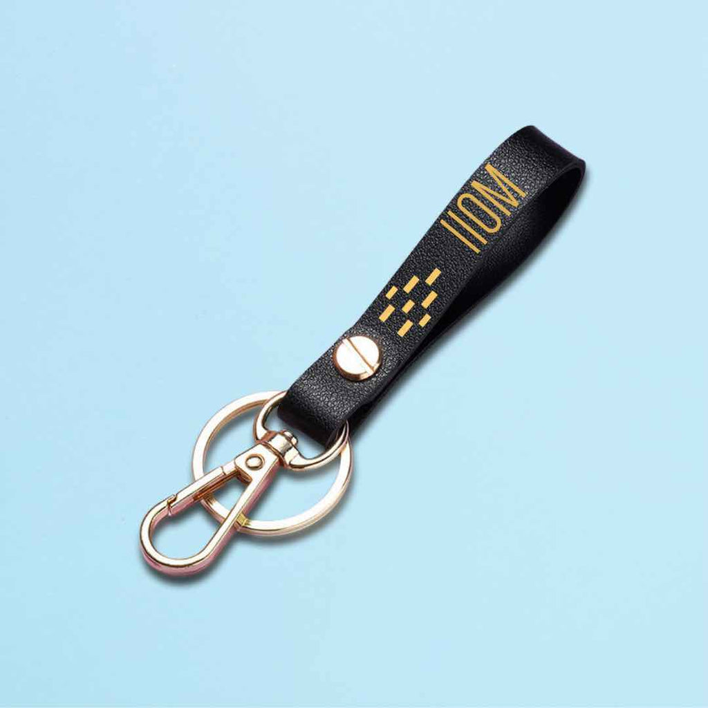 "A close-up photo of a black leather keychain with a 110m hurdling hurdles with a metal finish, a stylish and functional accessory for track and field enthusiasts."